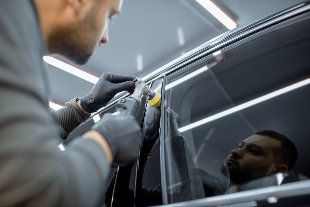 A technician performing professional auto glass polishing on a vehicle window in Ocala, FL.