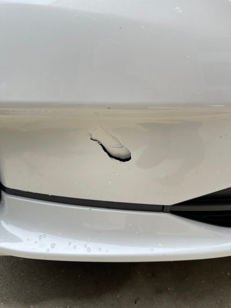 before and after comparison of car polishing and waxing on a dark sedan hood