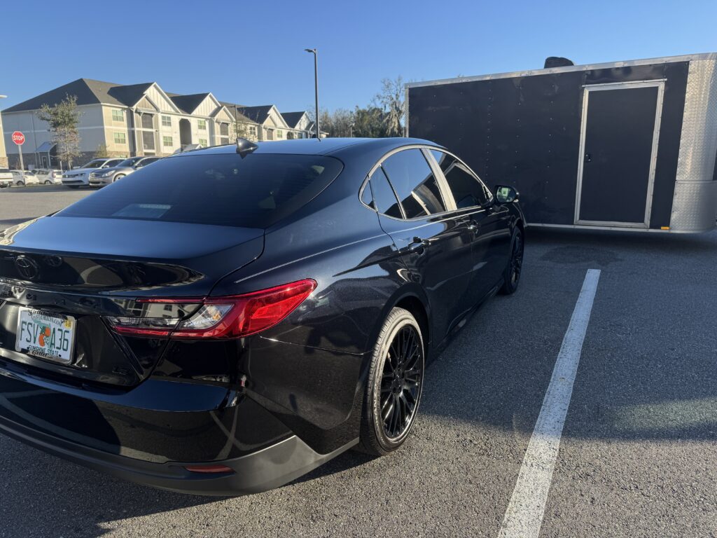 Ocala's Guide to Professional Auto Detailing That Protects Your Investment 1 technician performing professional auto detailing on a sedan in an Ocala driveway